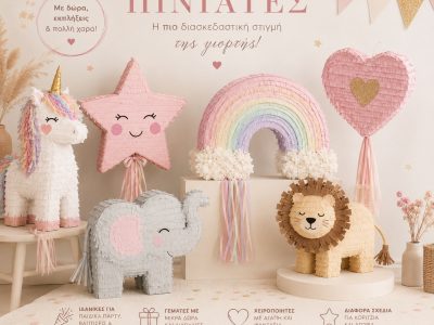 Pastel party piñata display with a unicorn, star, rainbow, heart, elephant and lion for a children's celebration setup. There is Greek text on the back wall.