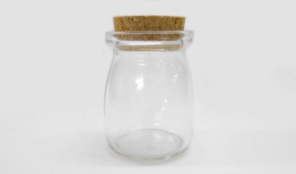 Small clear glass jar with a cork stopper, empty.