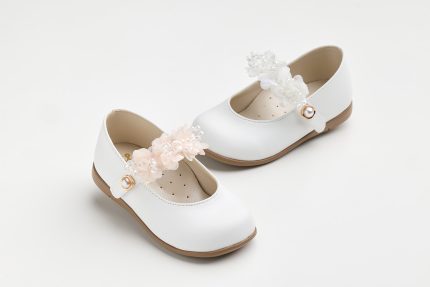 White Mary Jane shoes for kids with floral lace and pearl embellishments on a white background.