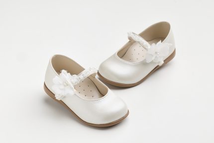 Pair of white children's dress shoes with lace straps and fabric flower embellishment