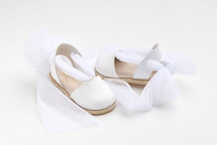 White open-toe sandals with a woven rope sole, wrapped in white fabric or tulle for presentation.