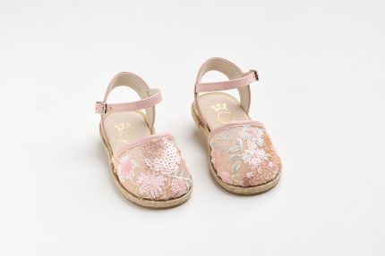 Pair of pink floral-patterned children's sandals with ankle straps on a white background.