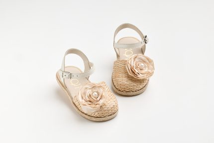 Beige espadrille sandals with floral fabric rose decorations on woven jute soles, shown from above-left.