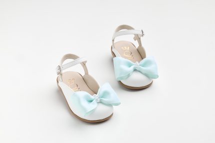 White children's sandals with mint satin bows on a white background, showing straps and beige insoles with a gold logo