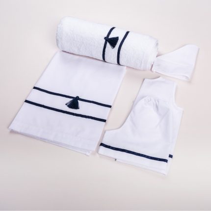White towel set with navy blue tassels and stripes, neatly arranged on a pale surface.