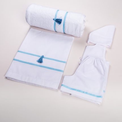 White baby bath set with blue trim and tassels, including towel, sheet, hooded towel, and romper laid out neatly