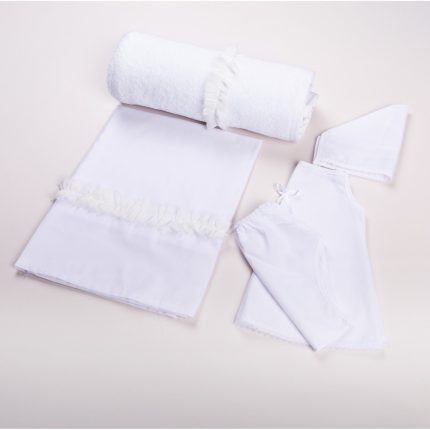 White baby linen set arranged on a pale surface: rolled towel with ruffle, a white blanket with gathered trim, a bonnet, and a matching romper with pants and lace trim.
