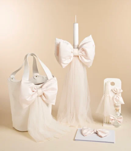 Ivory wedding decor set: tote bag and tall candle wrapped with large satin bows, with tulle accents in the display.