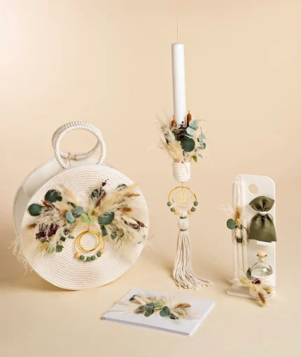Boho wedding decor set with a white woven bag, dried grasses, eucalyptus, and green-beaded rings on a beige background