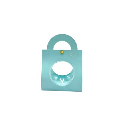Light blue padlock-shaped decorative object with a rounded transparent knob in the center and a small gold screw above it on a plain white background.