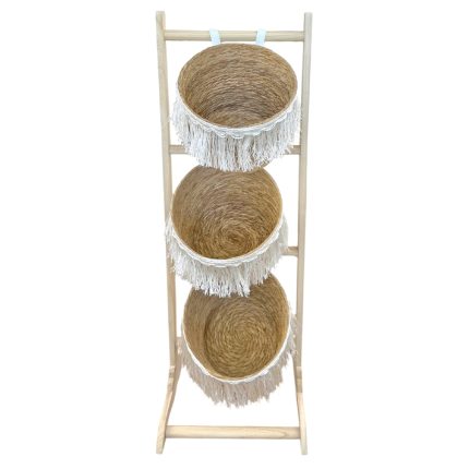 Wooden ladder-style rack holding three woven straw baskets with white fringe rims.