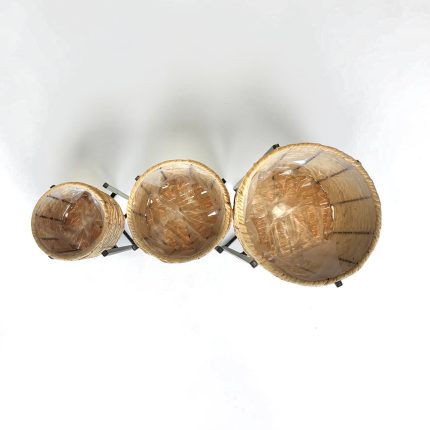 Overhead view of three round wicker baskets of different sizes on a metal stand, each with a clear plastic liner