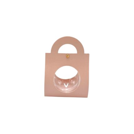Pink handbag with a circular cutout window on the front showing a glass orb inside.