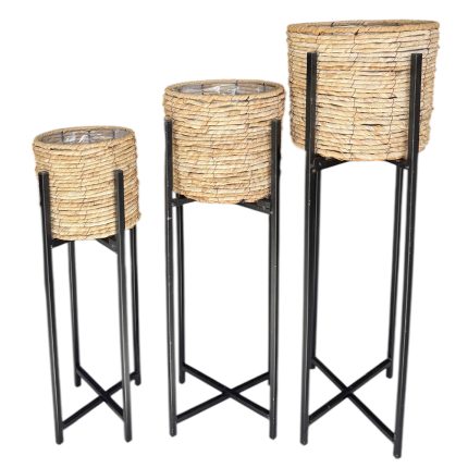 Set of three round wicker plant stands in varying heights on black metal frames.