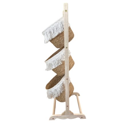 Wooden stand displaying four woven straw hats with white fringe trim stacked along the vertical rack