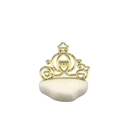 Gold ornate tiara with scrollwork resting on a white stone pedestal