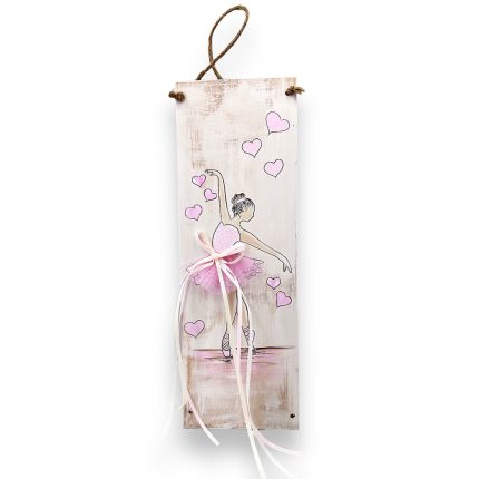 Narrow vertical wooden plaque featuring a pink-tutu ballerina drawing, surrounded by pink hearts, with pink and white ribbon accents and a hanging jute cord.