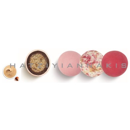 Row of pink and red macarons with a small bowl of creamy filling on the left.