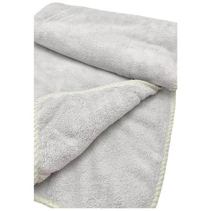 Soft light-gray bath towel with a pale cream edge, folded and rolled in the corner