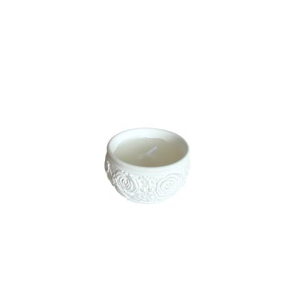 White ceramic votive holder with raised rose pattern and a small white candle inside.