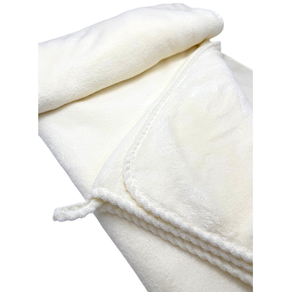 2B18CB75-210A-A173-AF66-019D04F24129_21 | La Vie en Rose Close-up of a soft white plush blanket with a folded corner and braided edge edge details.