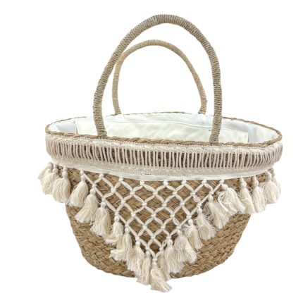 Woven straw tote basket with two handles and white fringe tassels along the rim, interior lined in white fabric. Press-style summer bag.