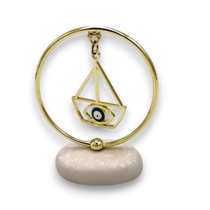 Gold circular pendant with a geometric triangle frame and an eye motif, hanging on a small stand.