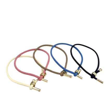 Set of five cord bracelets in cream, pink, light brown, blue, and black with gold bar clasps.