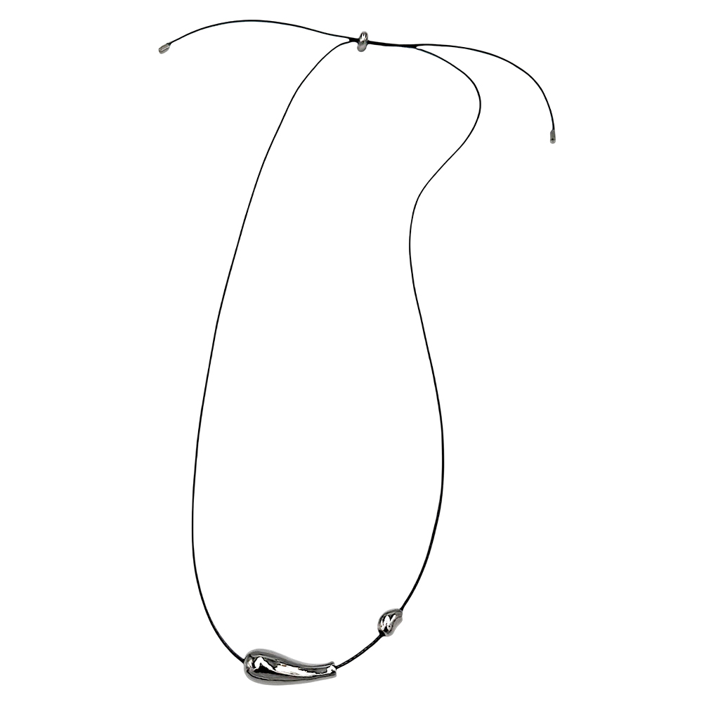 51F1AFB0-8E5A-DE69-46A2-019928DFE194_11 | La Vie en Rose Black cord necklace featuring a curved silver pendant at the bottom and small silver beads near the ends.