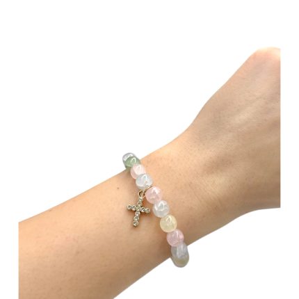 Pastel-colored bead bracelet with a small rhinestone cross charm on a wrist.