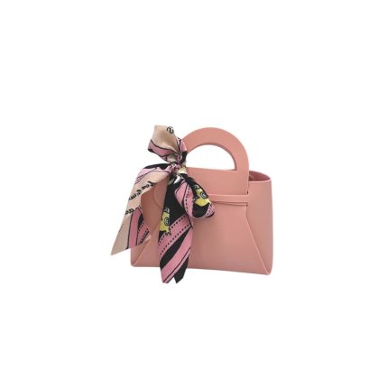 Small pink handbag with a rounded handle and a printed scarf tied in a bow on the side of the bag.