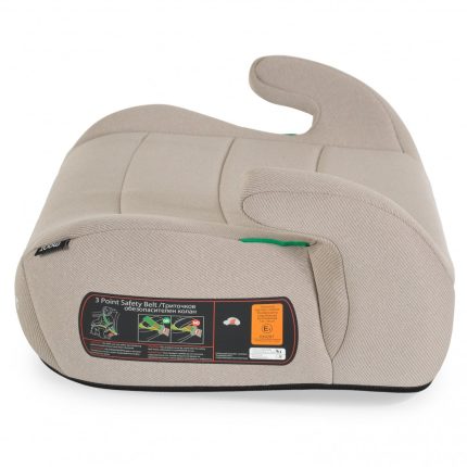 Beige child booster seat with armrests and a three-point safety belt, shown from the side with a label on the base edge.