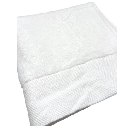 White folded white bath towel with a textured border edge