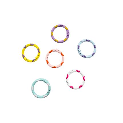 Six colorful plastic rings arranged on a white background, each with purple or orange abstract shapes.