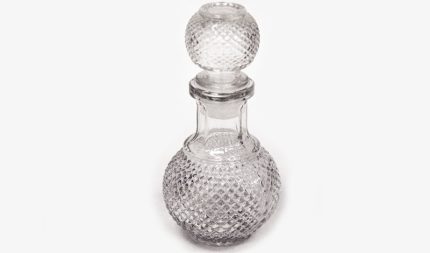 Clear glass perfume bottle with a diamond-cut pattern and a spherical stopper.