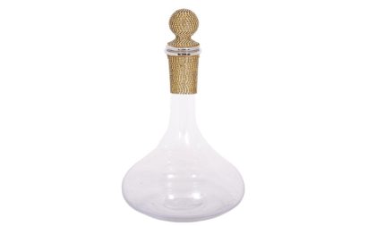 Clear glass decanter with a bulbous base and a gold beaded stopper.