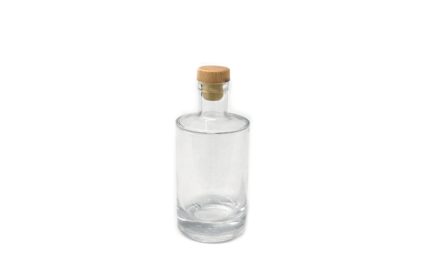 Clear glass bottle with a wooden cork stopper, empty inside.