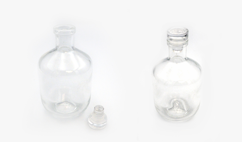 05034291 | La Vie en Rose Two empty clear glass bottles with stoppers on a white background