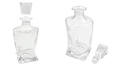 Two clear glass decanters with square bases and matching stoppers on a white background; one bottle has its stopper resting nearby, both empty.