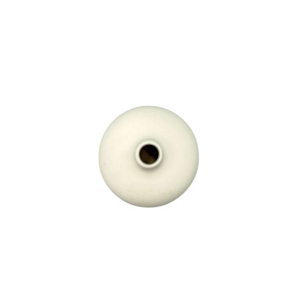 White donut-shaped bead with a central hole in the middle of the image
