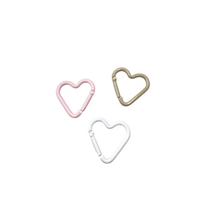 Three heart-shaped metal carabiners in pink, gold, and white on a white background.