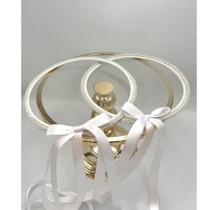 Three pearl-embellished hoop headbands with white satin ribbons, displayed on a gold stand (bridal hair accessories).