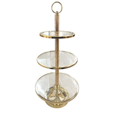 Gold-toned three-tier glass serving stand with circular shelves and a ring handle on top for lifting/carrying