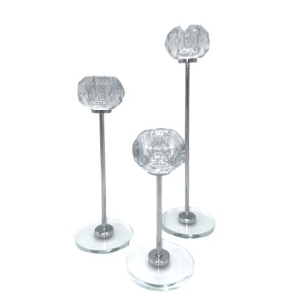 Three crystal-topped decorative candle holders on metal stems of varying heights with clear glass bases.