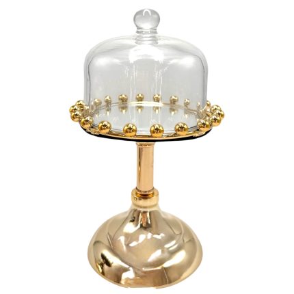 Gold pedestal cake stand with a glass cloche and bead detailing around the rim on a white background