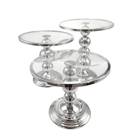 Three-tier silver cake stand with clear glass plates and a polished chrome base, standing upright on a circular pedestal.