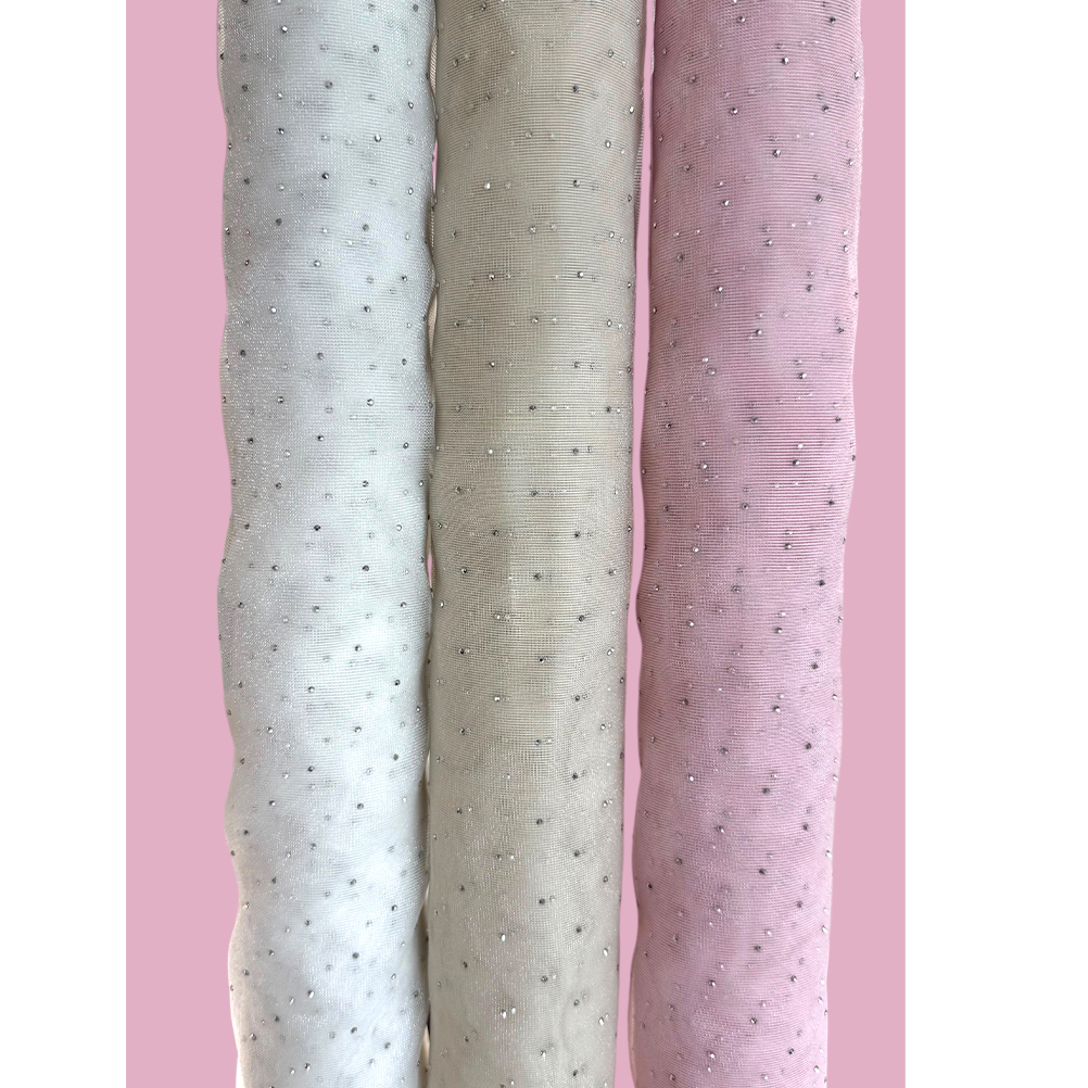 D4B986A5-B3FE-1D65-FEDD-019D2ECCE93D_21 | La Vie en Rose Three rolled pastel fabrics (blue, beige, pink) with small bead-like embellishments against a pink background.