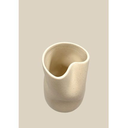 Top-down view of a cream-colored ceramic cup with an irregular, wavy rim.