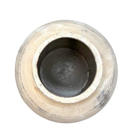 Top-down view of a weathered circular metal pipe opening with a dark inner bore.