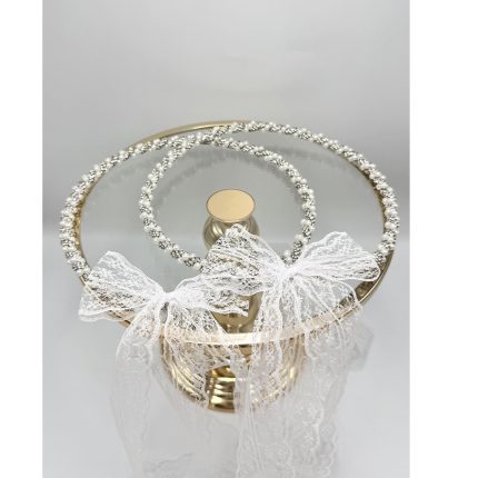 Two diamond-studded headbands on a round mirrored tray tied with white lace for a bridal look